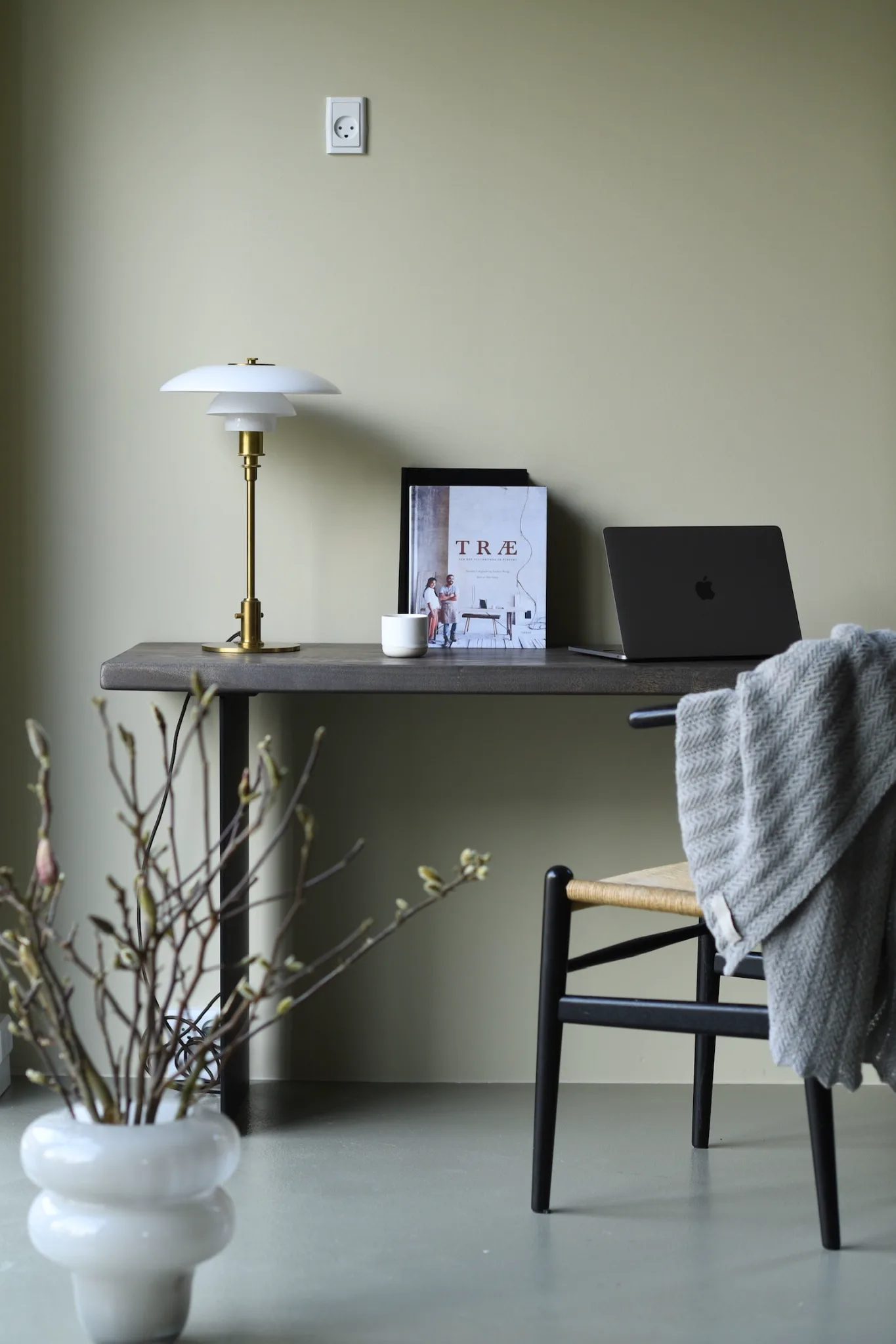 Håndlavet arbejdsbord i træ indrettet med lampe og laptop